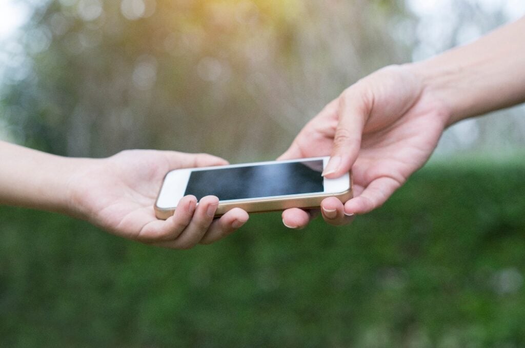 A mother giving her child a mobile phone